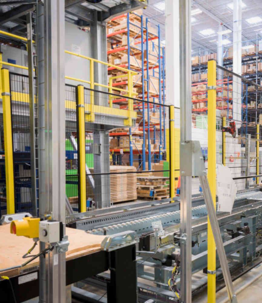 Figure 2: This warehousing installation shows physical fencing to guard users from the moving equipment, and an e-stop button (lower left) so users can rapidly force all equipment to a safe state. Courtesy: AutomationDirect