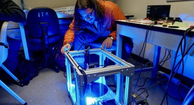 Marty LaRocque looks over the team's silicon wafer center-finding improvement device. Courtesy: Colorado University.