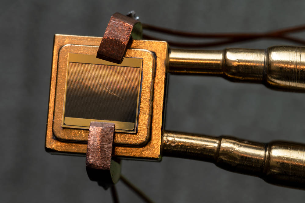 A thermophotovoltaic (TPV) cell (size 1 cm x 1 cm) mounted on a heat sink designed to measure the TPV cell efficiency. To measure the efficiency, the cell is exposed to an emitter and simultaneous measurements of electric power and heat flow through the device are taken. Courtesy: Felice Frankel, MIT