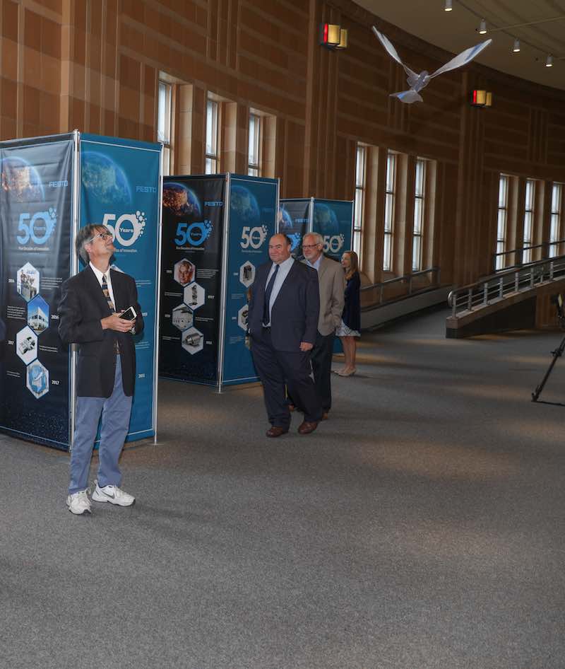 A guest at the Festo 50th Anniversary Gala marvels at the lifelike flight of the Festo Bionic Swift. Courtesy of: Festo U.S.