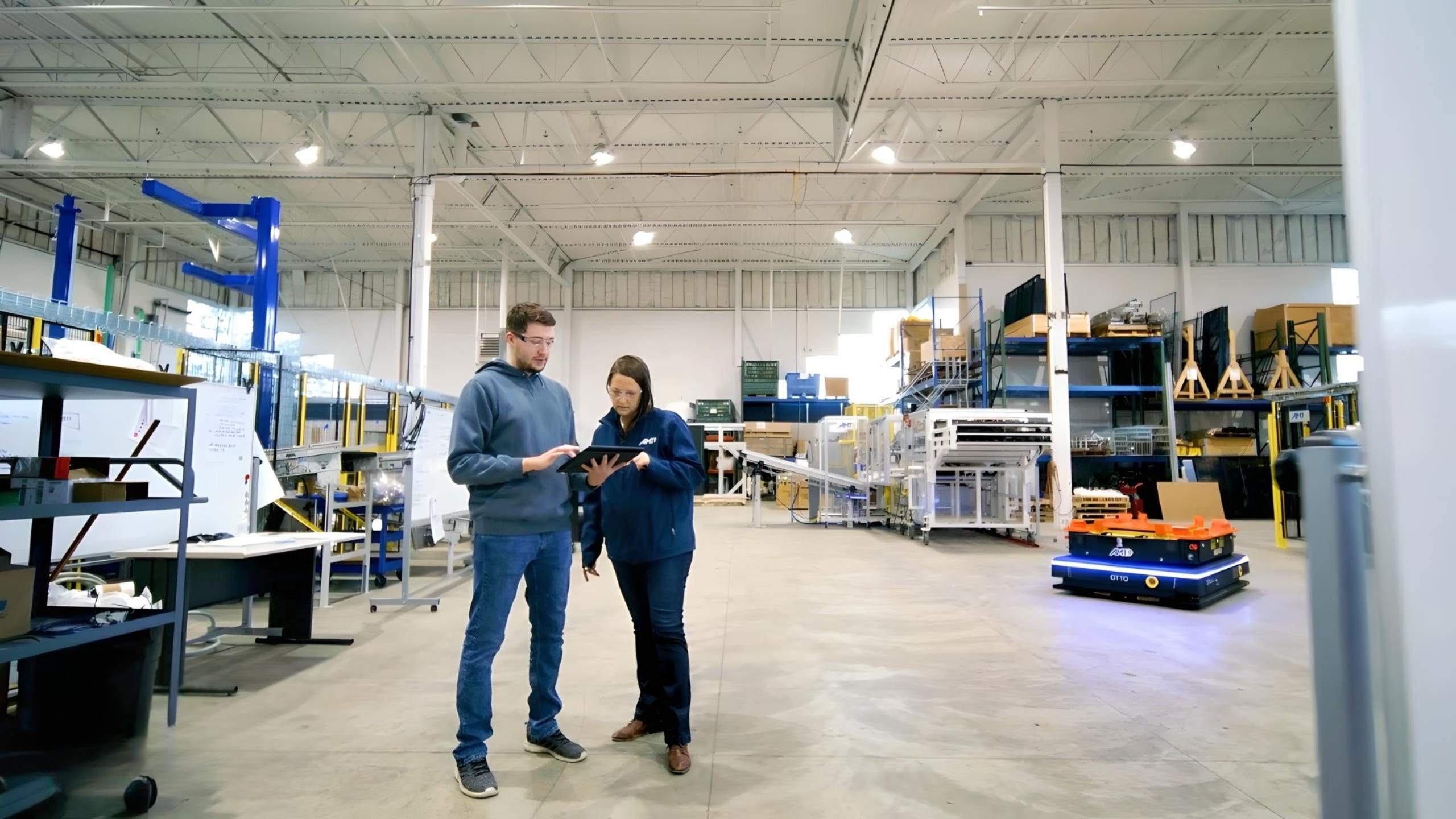 Figure 4: Engineers collaborate using OTTO Motors' autonomous mobile robot in a warehouse setting, highlighting the integration of advanced robotics into industrial workflows. Courtesy: Applied Manufacturing Technologies (AMT)