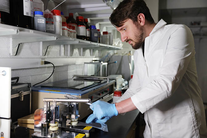 Colton Rainey, a PhD student in mechanical engineering makes batteries at the Lu Lab. Photo: Brenda Ahearn. Courtesy: University of Michigan.