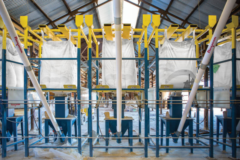 Figure 1: Five bulk bag dischargers and five pairs of flexible screw conveyors automatically batch clays and grogs (recycled ceramic material) into the mixer. Courtesy: Flexicon Corp.
