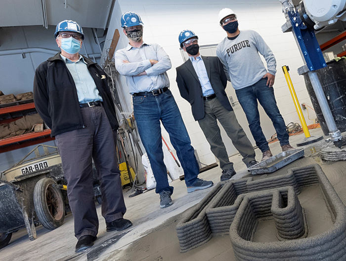 Purdue University engineers (from left) Jan Olek, Jeffrey P. Youngblood and Pablo Zavattieri conduct research with Ph.D. student Fabian B. Rodriguez (far right) on concrete 3D printing technology from RCAM Technologies.
