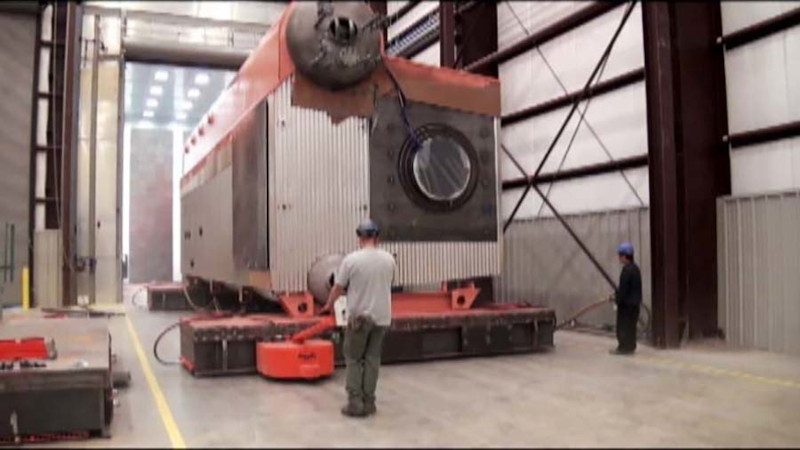 A 100-ton boiler is driven through a plant door using a power drive and air casters.