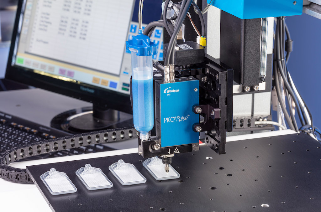 Figure 7: xQR4IV needle valve dispensing UV-cure material onto a medical device. Courtesy: Nordson EFD