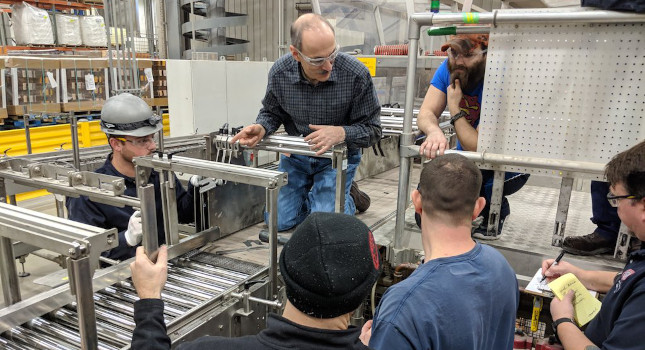 The author is shown troubleshooting conveyor issues with users.