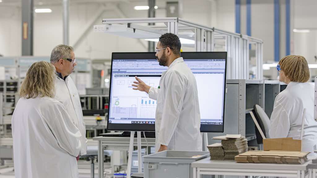 Figure 1: During the daily Gemba walk, Donna Sheaffer, Todd Madden, Justin Jones and Bernice Ritter review the data collection on the interactive, mobile Gemba board in the industrial dlectronics production area. Courtesy: Phoenix Contact