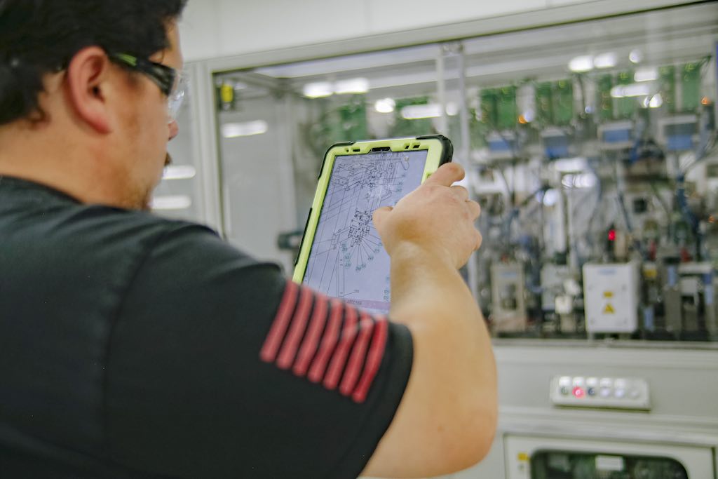 Figure 4: Robert McCleary uses an augmented reality application to locate instructions and part lists and to log maintenance activities on an automated machine. Courtesy: Phoenix Contact