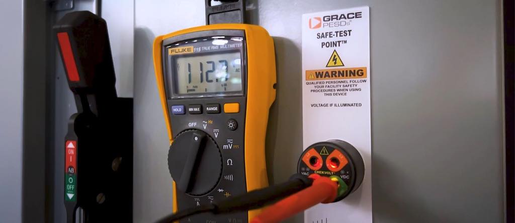 Figure 2: A portable test instrument with meter probes inserted into a ChekVolt permanent electrical safety device's high impedance protected test points. Courtesy: Grace Technologies
