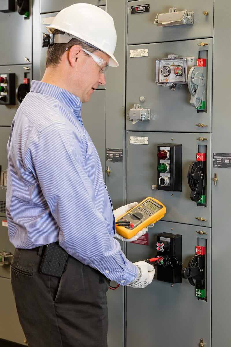 Figure 1: A qualified worker using a portable test instrument to test for voltage through a UL 61010 test point permanent electrical safety device (PESD). Courtesy: Grace Technologies Inc.