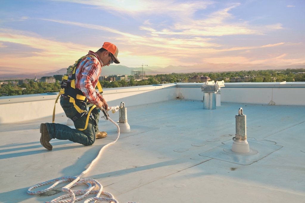Worker verifying proper tension of personal fall protection system.