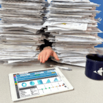 Figure 2: A hand reaches from a pile of paperwork toward a digital dashboard, signaling the shift toward efficient, paperless operations. Courtesy: Applied Control Engineering