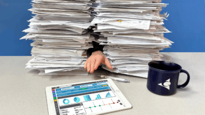 Figure 2: A hand reaches from a pile of paperwork toward a digital dashboard, signaling the shift toward efficient, paperless operations. Courtesy: Applied Control Engineering
